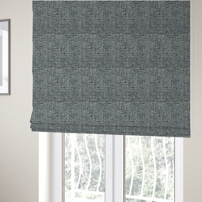 The fabric used to create these Roman blinds is a dense, textured woven fabric in a charcoal and ash-grey salt-and-pepper pattern. The weave features tightly packed, nubby bouclé yarns with a subtle vertical and horizontal grid-like structure.