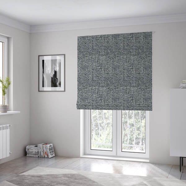 The fabric used to create these Roman blinds is a dense, textured woven fabric in a charcoal and ash-grey salt-and-pepper pattern. The weave features tightly packed, nubby bouclé yarns with a subtle vertical and horizontal grid-like structure.