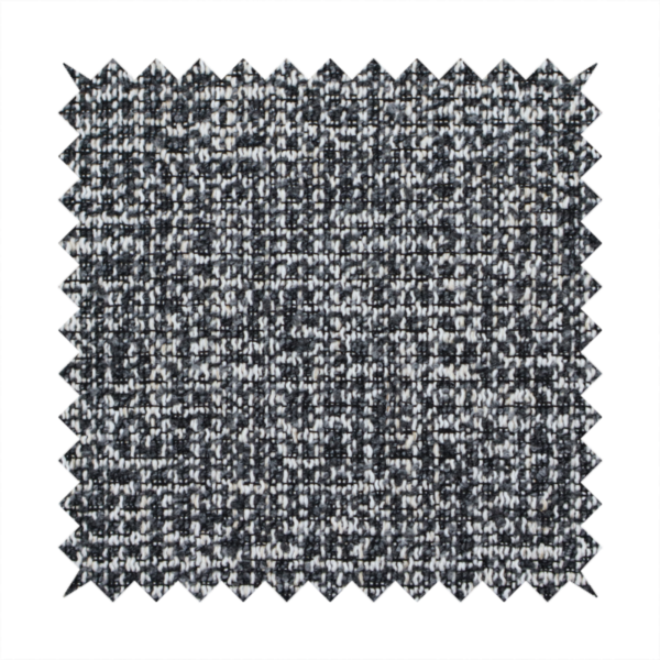 A dark, heavyweight woven fabric with a charcoal and slate-grey salt-and-pepper pattern. The dense bouclé weave creates a highly textured, pebbled surface with subtle off-white specks.