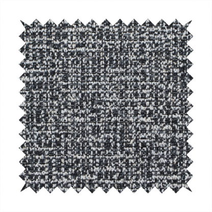 A dark, heavyweight woven fabric with a charcoal and slate-grey salt-and-pepper pattern. The dense bouclé weave creates a highly textured, pebbled surface with subtle off-white specks.
