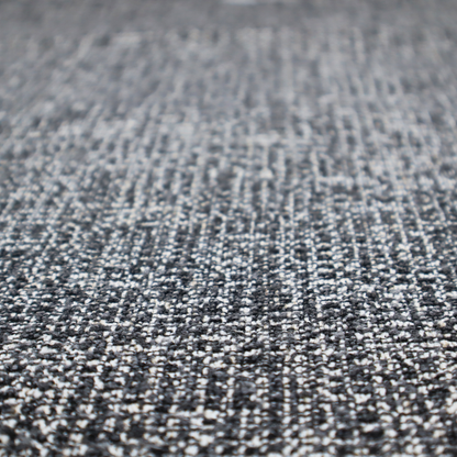 A dark, heavyweight woven fabric with a charcoal and slate-grey salt-and-pepper pattern. The dense bouclé weave creates a highly textured, pebbled surface with subtle off-white specks.