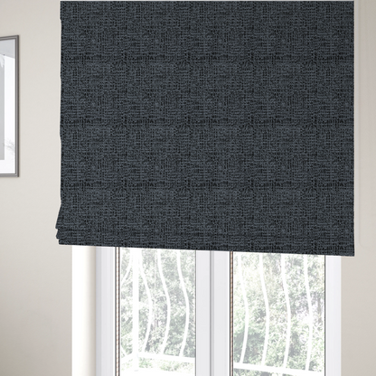 The fabric used to create these Roman blinds is a dark, heavyweight woven fabric with a deep slate and charcoal marl pattern. The dense bouclé weave creates a low-contrast, pebbled texture with a uniform, dark grey appearance.
