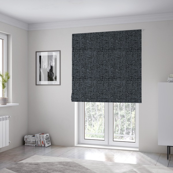 The fabric used to create these Roman blinds is a dark, heavyweight woven fabric with a deep slate and charcoal marl pattern. The dense bouclé weave creates a low-contrast, pebbled texture with a uniform, dark grey appearance.