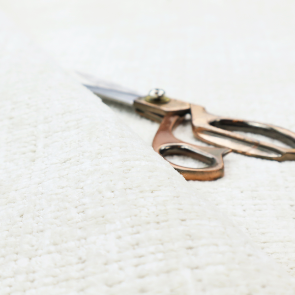 An off-white upholstery fabric. The material features a chunky, nubby boucle texture arranged in a soft horizontal and vertical grid pattern, creating a cosy and dimensional tactile surface.