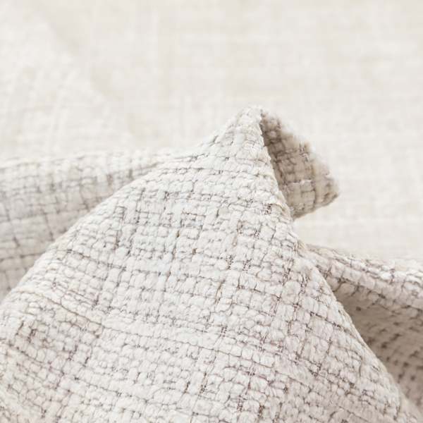 A cream and oatmeal-toned fabric. The material features a chunky, multi-tonal boucle weave with a distinct grid pattern and organic snubbed yarns, creating a dimensional and rustic look.