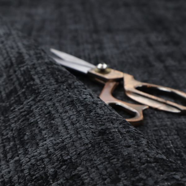 A dark charcoal upholstery fabric. The material features a heavy boucle texture with a prominent, recessed grid pattern, creating a rich, tactile surface with deep shadows and sophisticated dark grey tones.