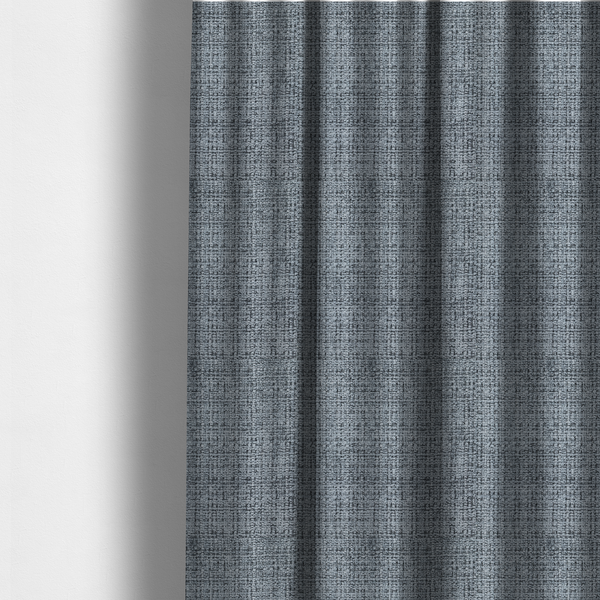 The fabric used to create these made-to-measure curtains is a slate blue and grey textured boucle fabric with a dense, dimensional grid weave.