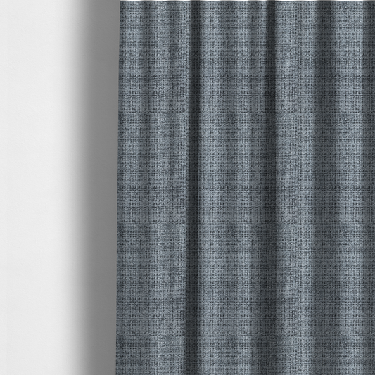 The fabric used to create these made-to-measure curtains is a slate blue and grey textured boucle fabric with a dense, dimensional grid weave.