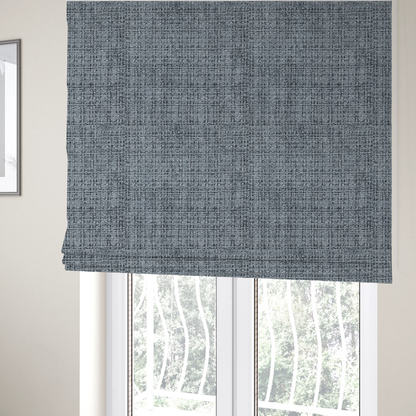 The fabric used to create these Roman blinds is a slate blue and grey textured boucle fabric with a dense, dimensional grid weave.