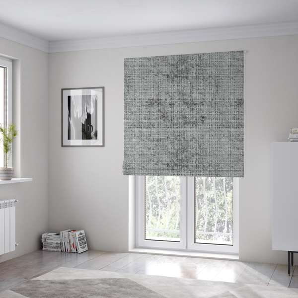 The fabric used to create these Roman blinds is a silver-grey textured boucle fabric with a dimensional grid weave and mottled grey accents.