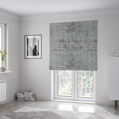 The fabric used to create these Roman blinds is a silver-grey textured boucle fabric with a dimensional grid weave and mottled grey accents.