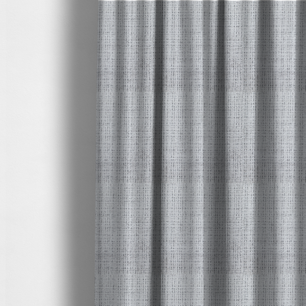 The fabric used to create these made-to-measure curtains is a light grey upholstery fabric. This material features a dense boucle texture with a prominent architectural grid pattern. The weave combines pale grey and charcoal-flecked yarns, creating a sophisticated, salt-and-pepper dimensional effect.