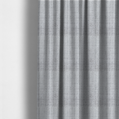 The fabric used to create these made-to-measure curtains is a light grey upholstery fabric. This material features a dense boucle texture with a prominent architectural grid pattern. The weave combines pale grey and charcoal-flecked yarns, creating a sophisticated, salt-and-pepper dimensional effect.