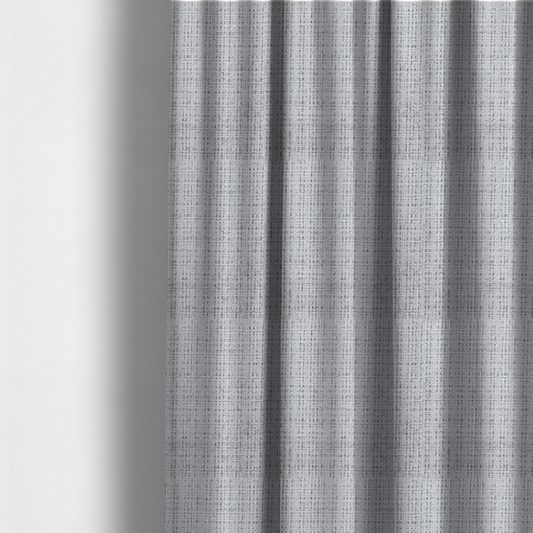 The fabric used to create these made-to-measure curtains is a light grey upholstery fabric. This material features a dense boucle texture with a prominent architectural grid pattern. The weave combines pale grey and charcoal-flecked yarns, creating a sophisticated, salt-and-pepper dimensional effect.