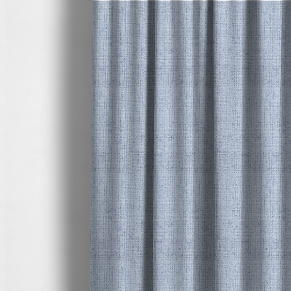The fabric used to create these made-to-measure curtains is a Scanno weave upholstery fabric in an Ice Blue shade, featuring a textured, woven pattern with small, grid-like interlocking threads.