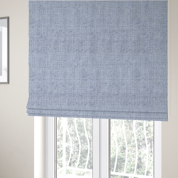 The fabric used to create these Roman blinds is a Scanno weave upholstery fabric in an Ice Blue shade, featuring a textured, woven pattern with small, grid-like interlocking threads.