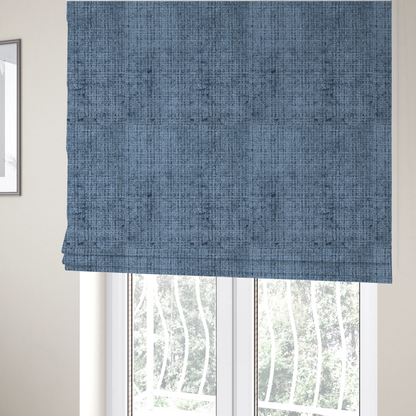 The fabric used to create these Roman blinds is a Scanno Weave upholstery fabric in a medium blue shade, featuring a detailed, woven texture with an interlocking grid pattern.