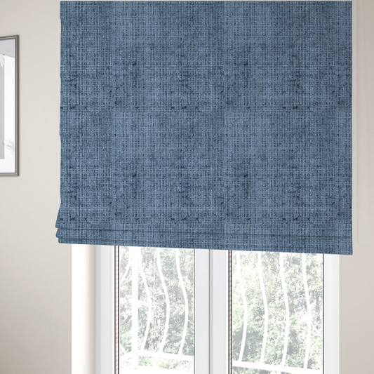 The fabric used to create these Roman blinds is a Scanno Weave upholstery fabric in a medium blue shade, featuring a detailed, woven texture with an interlocking grid pattern.