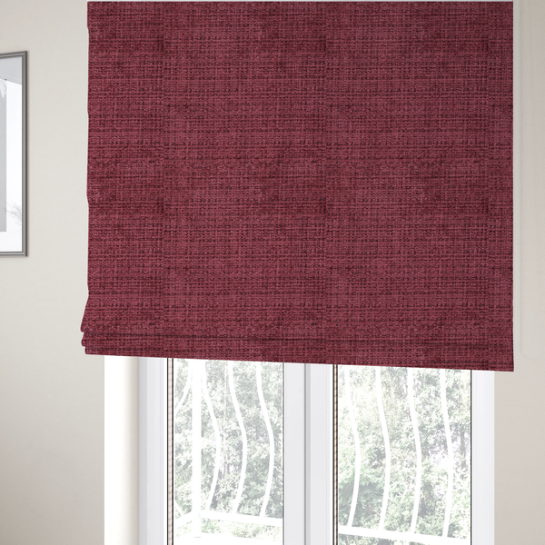The fabric used to create these Roman blinds is a Scanno Weave upholstery fabric in a deep red shade, showcasing a detailed, woven texture with an interlocking grid pattern.