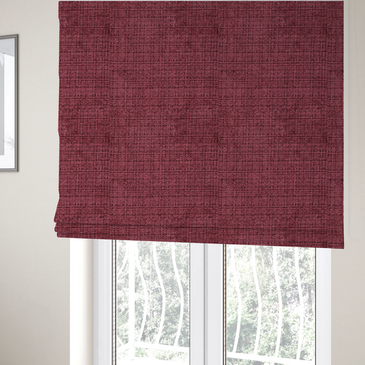 The fabric used to create these Roman blinds is a Scanno Weave upholstery fabric in a deep red shade, showcasing a detailed, woven texture with an interlocking grid pattern.
