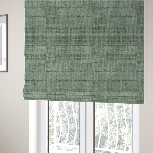 The fabric used to create these Roman blinds is a Scanno Weave upholstery fabric in a soft mint green shade, showcasing a detailed, woven texture with an interlocking grid pattern.