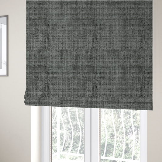The fabric used to create these Roman blinds is a Scanno Weave upholstery fabric in a neutral grey shade, featuring a detailed, woven texture with an interlocking grid pattern.