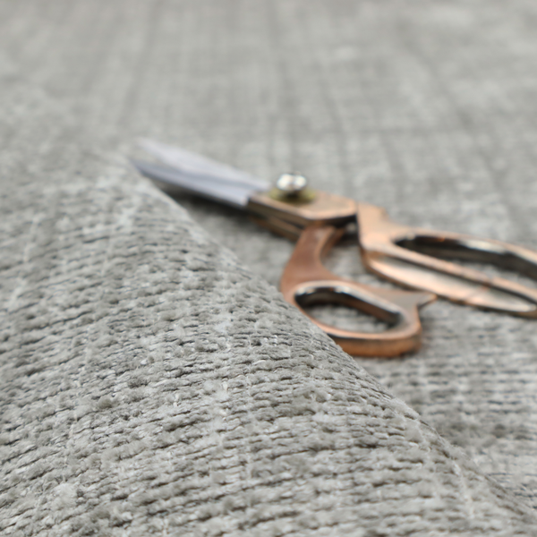 Scanno Weave upholstery fabric in a light grey shade, featuring a detailed, woven texture with an interlocking grid pattern.