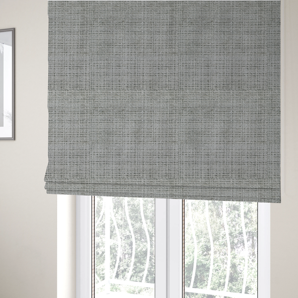 The fabric used to create these Roman blinds is a Scanno Weave upholstery fabric in a light grey shade, featuring a detailed, woven texture with an interlocking grid pattern.