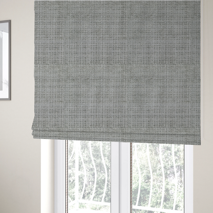 The fabric used to create these Roman blinds is a Scanno Weave upholstery fabric in a light grey shade, featuring a detailed, woven texture with an interlocking grid pattern.