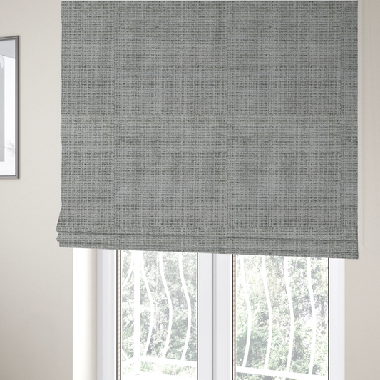 The fabric used to create these Roman blinds is a Scanno Weave upholstery fabric in a light grey shade, featuring a detailed, woven texture with an interlocking grid pattern.