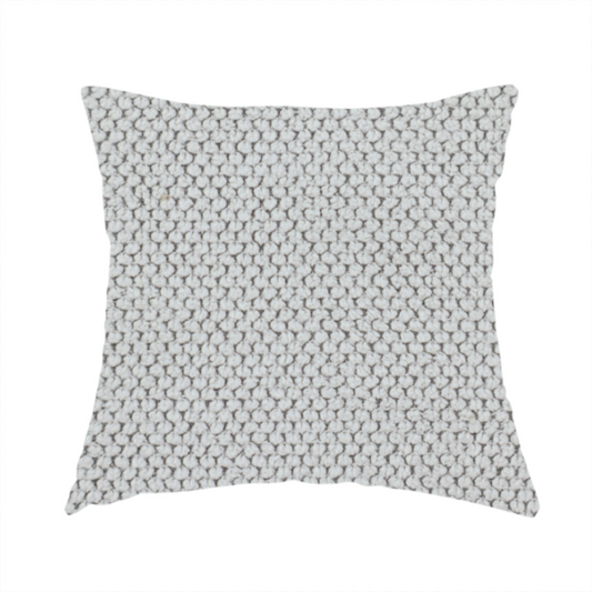 The fabric used to create these handmade cushions is a waffle-knit or honeycomb-patterned weave characterized by a repeating, three-dimensional grid of soft, raised textures. Its off-white or light grey tone and uniform geometric structure suggest a cosy, high-quality material, commonly found in thermal apparel, heavy cotton blankets, or sophisticated upholstery. The dense, woven design provides a matte appearance with a subtle, visually rich depth.