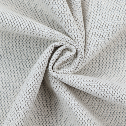 A waffle-knit or honeycomb-patterned weave characterized by a repeating, three-dimensional grid of soft, raised textures. Its off-white or light grey tone and uniform geometric structure suggest a cosy, high-quality material, commonly found in thermal apparel, heavy cotton blankets, or sophisticated upholstery. The dense, woven design provides a matte appearance with a subtle, visually rich depth.
