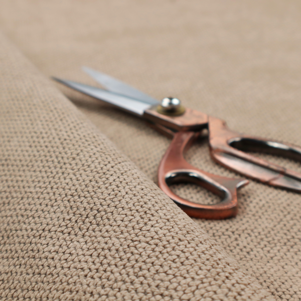 A waffle-knit or honeycomb-patterned weave, defined by a uniform, three-dimensional grid of raised, rounded textures. Its warm, inviting tan or light brown hue and matte finish provide an elegant, cosy aesthetic. This structured, high-quality material is an excellent choice for luxury upholstery, decorative cushions, and premium home textiles that require a blend of durability and timeless style.