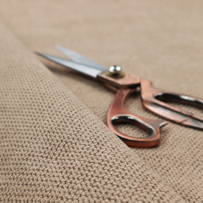 A waffle-knit or honeycomb-patterned weave, defined by a uniform, three-dimensional grid of raised, rounded textures. Its warm, inviting tan or light brown hue and matte finish provide an elegant, cosy aesthetic. This structured, high-quality material is an excellent choice for luxury upholstery, decorative cushions, and premium home textiles that require a blend of durability and timeless style.