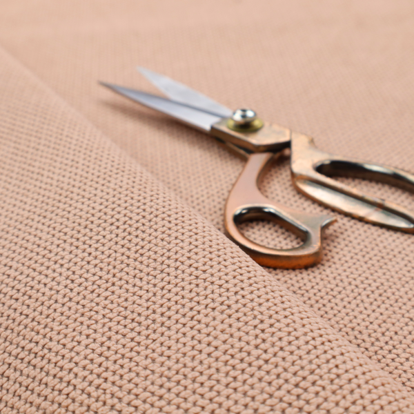 A waffle-knit or honeycomb-patterned weave, defined by a uniform, three-dimensional grid of raised, rounded textures. Its soft, warm peach or dusty rose hue and matte finish provide an elegant, cosy aesthetic. This structured, high-quality material is an excellent choice for luxury upholstery, decorative cushions, and premium home textiles that require a blend of durability and timeless style.