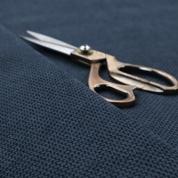 A premium navy blue waffle-knit fabric, highlighting a dense, three-dimensional honeycomb weave for luxury home decor.