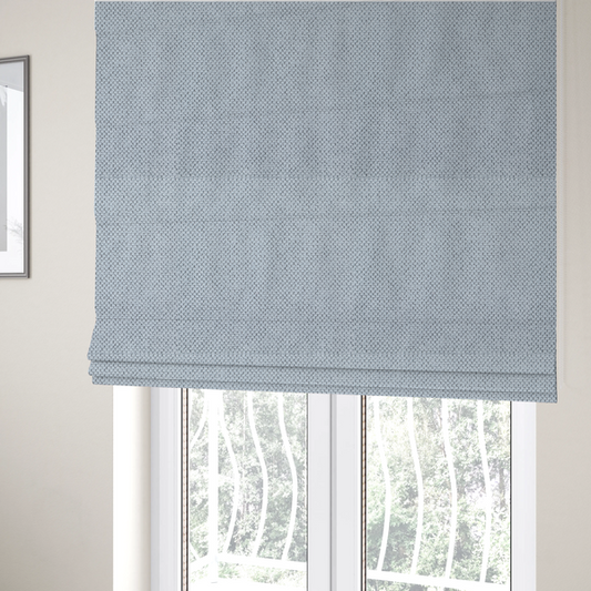 The fabric used to create these Roman blinds is a premium pale ice blue waffle-knit fabric, showcasing a crisp, structured, and sophisticated honeycomb texture.