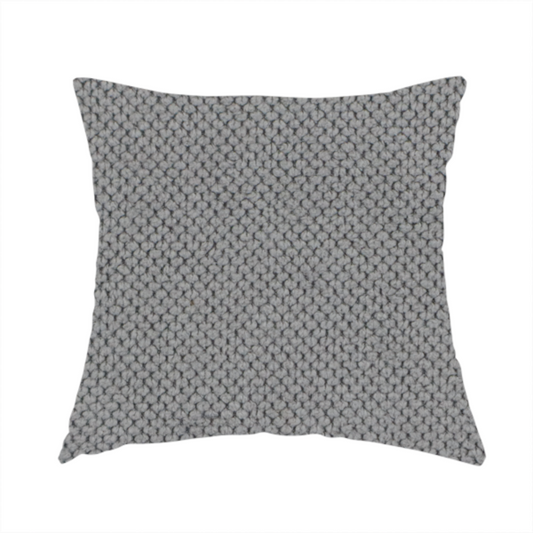 The fabric used to create this handmade cushion is a light grey upholstery fabric. The material features a tightly woven, multidimensional texture that creates a soft, grainy appearance across the entire surface.