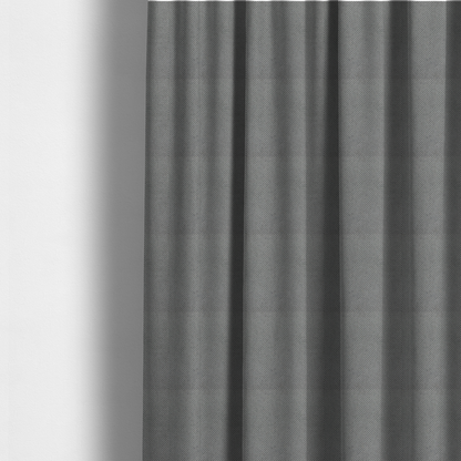 The fabric used to create these made-to-measure curtains is a light grey upholstery fabric. The material features a tightly woven, multidimensional texture that creates a soft, grainy appearance across the entire surface.