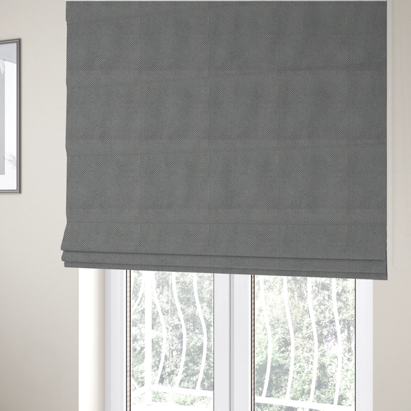 The fabric used to create these Roman blinds is a light grey upholstery fabric. The material features a tightly woven, multidimensional texture that creates a soft, grainy appearance across the entire surface.