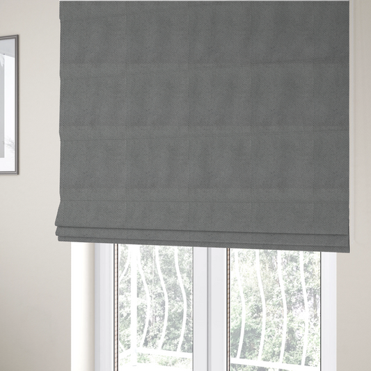 The fabric used to create these Roman blinds is a light grey upholstery fabric. The material features a tightly woven, multidimensional texture that creates a soft, grainy appearance across the entire surface.