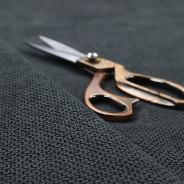 A premium charcoal grey waffle-knit fabric, featuring a dense, three-dimensional honeycomb weave for a sophisticated, modern aesthetic.