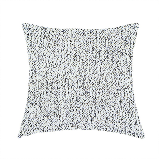 The fabric used to create this handmade cushion is a textured white fabric with an intricate, irregular black speckled pattern throughout.