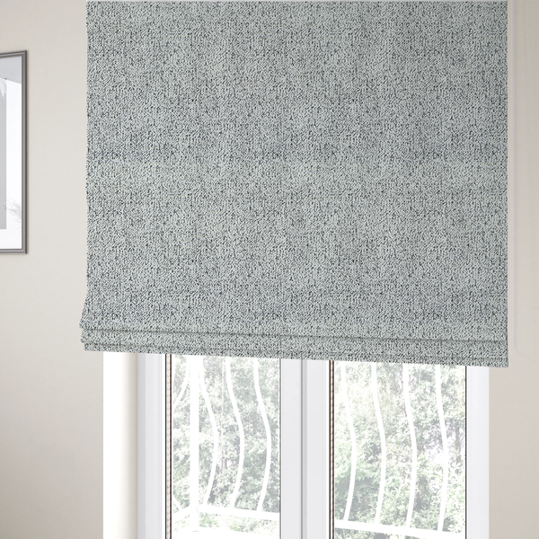The fabric used to create these Roman blinds is a textured white fabric with an intricate, irregular black speckled pattern throughout.