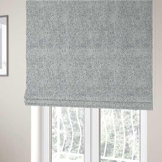 The fabric used to create these Roman blinds is a textured white fabric with an intricate, irregular black speckled pattern throughout.