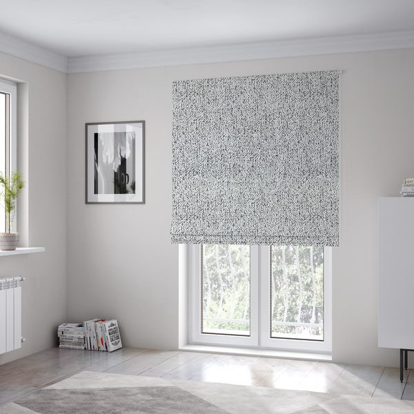 The fabric used to create these Roman blinds is a textured white fabric with an intricate, irregular black speckled pattern throughout.