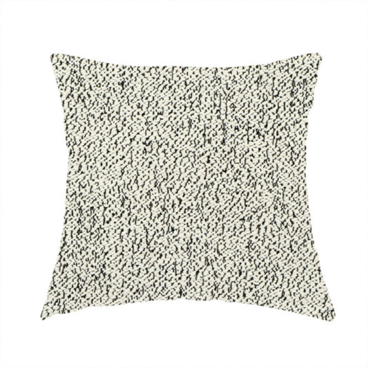 The fabric used to create these handmade cushions is a cream-coloured textured fabric with a dense, irregular black speckled pattern.