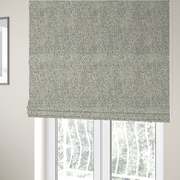 The fabric used to create these Roman blinds is a cream-coloured textured fabric with a dense, irregular black speckled pattern.