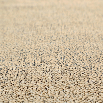 A beige textured fabric with a dense, irregular black speckled pattern.