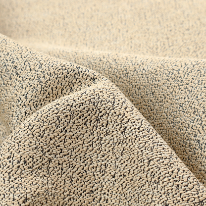 A beige textured fabric with a dense, irregular black speckled pattern.